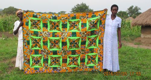 Project 203 Large size quilt in greens, oranges and purple.